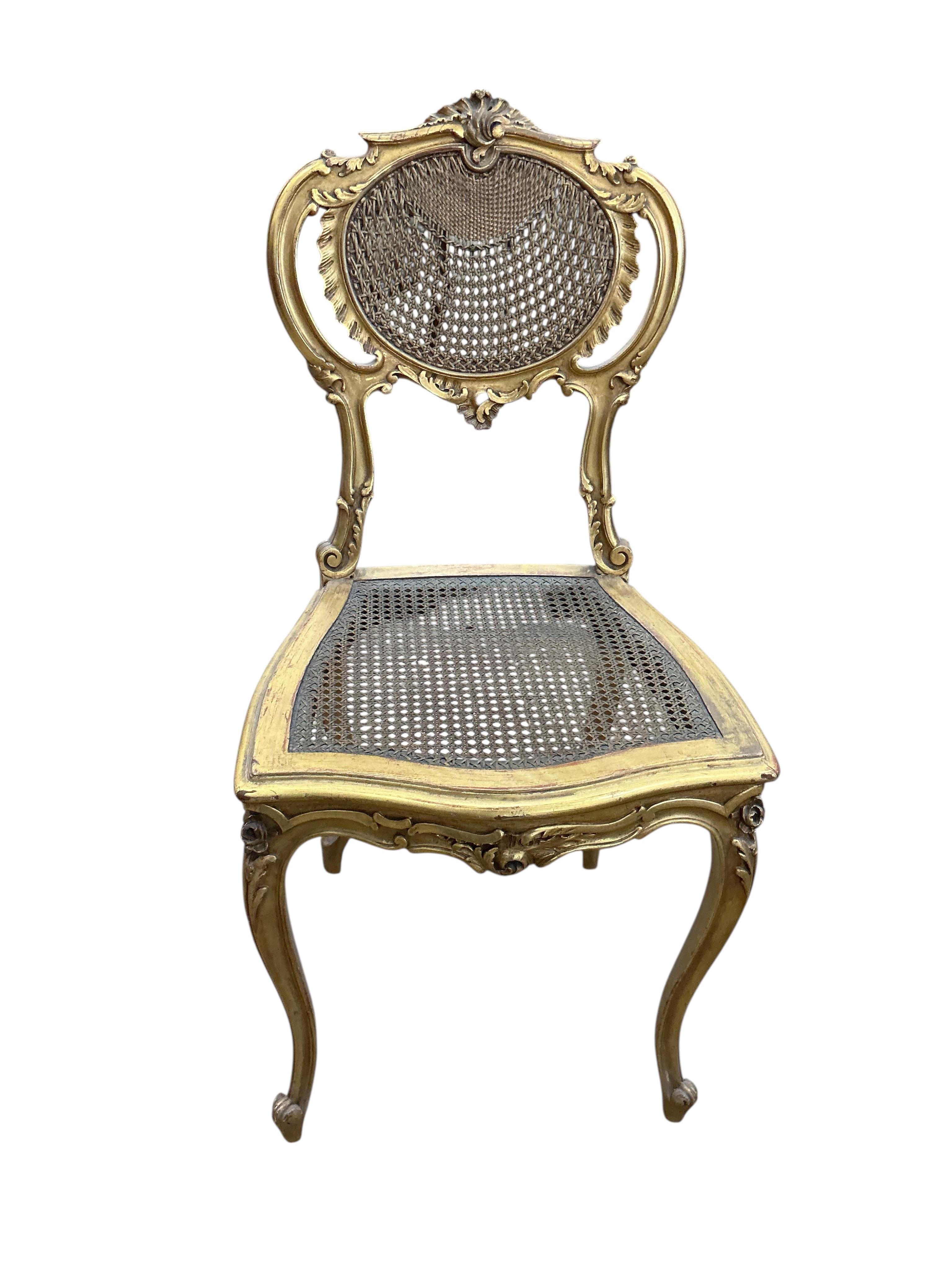 A late 19th century French Louis XVI style open elbow chair with cane seat, a matching side chair and another giltwood side chair